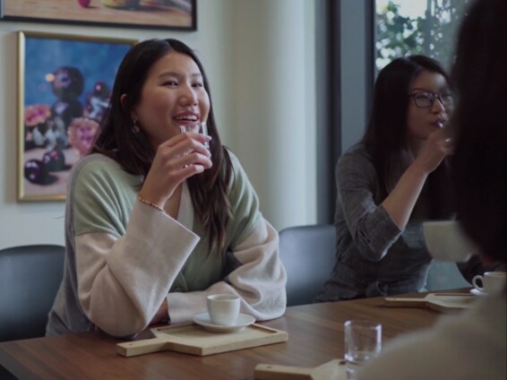 Group of women having a conversation while holding glass.